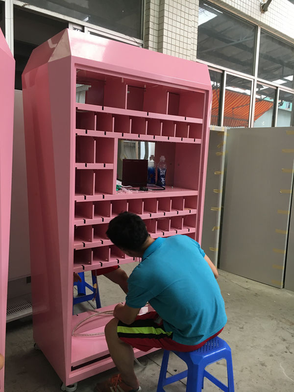 Worker assembling a pink vending machine